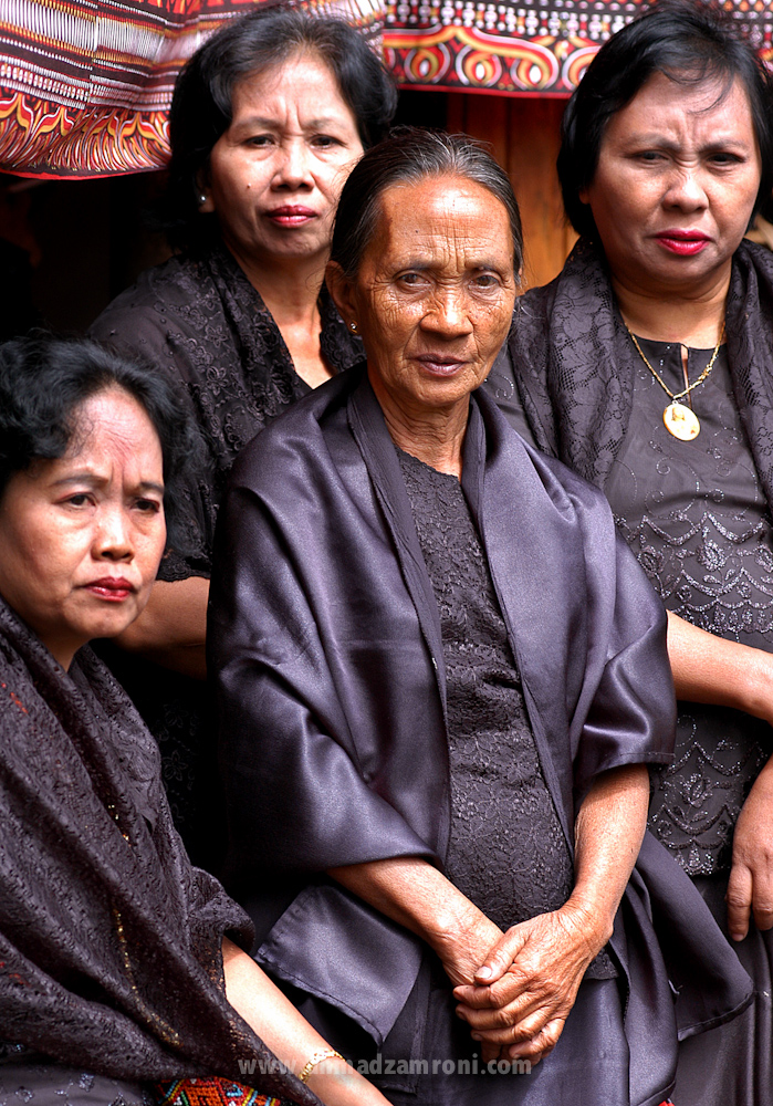 KELUARGA. Keluarga almarhum dengan berbakaian hitam-hitam turut menyaksikan jalannya upacara pemakaman. Tidak ada raut muka murung di wajah mereka karena menyelenggarakan upacara merupakan kebanggaan juga kebahagiaan. Funeral, Toraja, Indonesia
